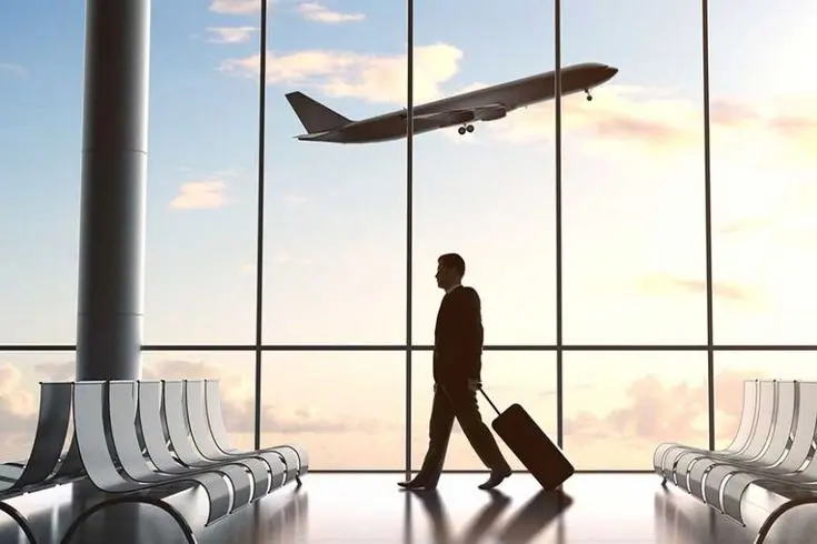 Passageiro no terminal de aeroporto, com avião ao fundo